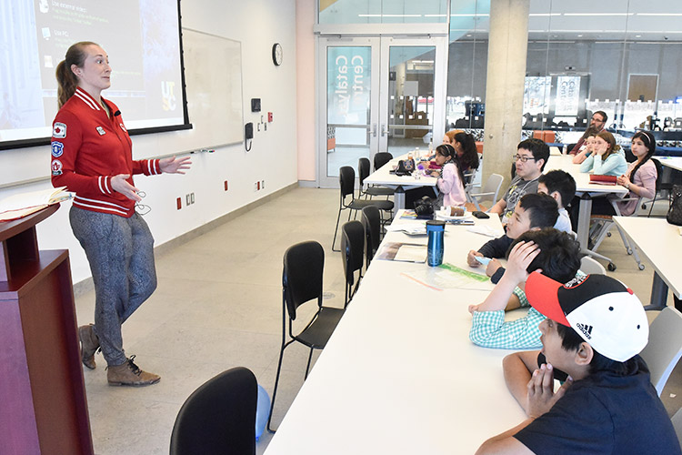 Rosie Cossar speaking to a lecture hall filled with children.