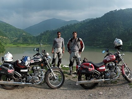 Ryan Pyle with brother Colin standing in front of a large lake and tree covered mountains. 