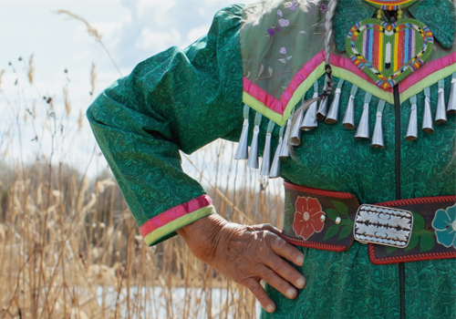 A green dress with fine stitching and details.