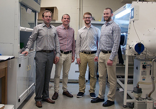 Dwight Seferos with postdoctoral fellow Andrew Tilley and PhD students Mark Miltenburg and Tyler Schon standing in a lab.