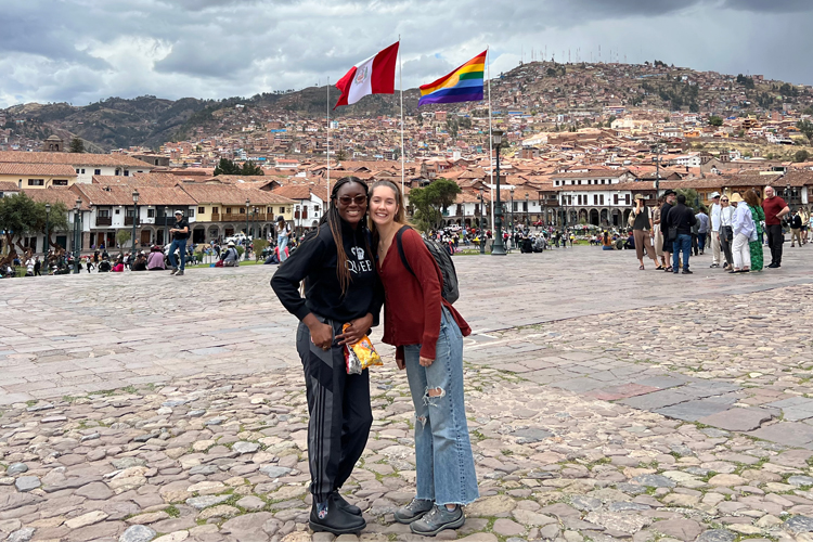 Sharese Taylor (left) and Elle Gilbert standing in a beautiful town.