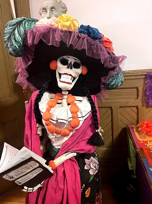 Figure of a Mexican Catrina - a festively dressed skeleton with a large hat.