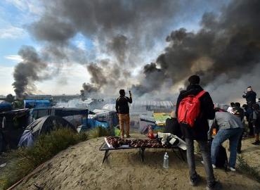 Smoke billows from Calais refugee camp.