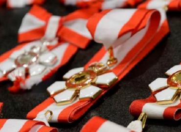 A red and white ribbon with gold medal.