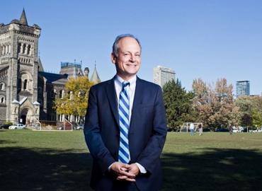 Meric Gertler standing on campus with University College in the background