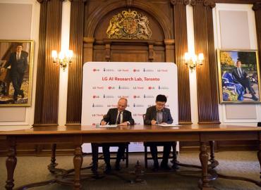 U of T President Meric Gertler and I.P. Park, the president and CTO of LG Electronics, signing documents at a large table.