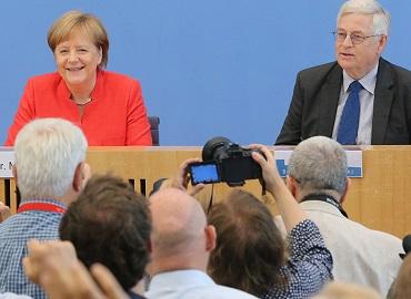 German Chancellor Angela Merkel attends a Bundespressekonferenz in July of 2018, with Gregor Mayntz (right).