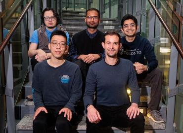 Assistant Professor Joseph Jay Williams (front right) with graduate students on the Adaptive Experimentation Accelerator team, including (from left to right) Ilya Musabirov, Pan Chen, Harsh Kumar and Mohi Reza sitting on a staircase.