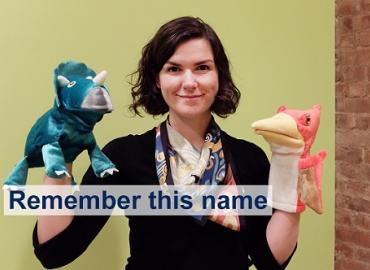 Ailís Cournane holding two dinosaur hand puppets