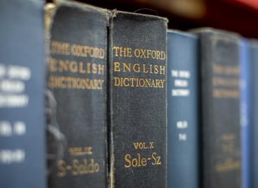 The Oxford English Dictionary on a shelf with other books