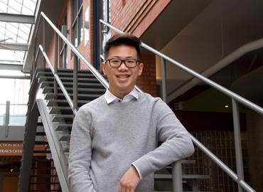 Ethan Kim in front of metal stairs at Innis College