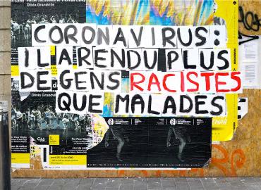 A large colourful poster on a city wall that says, &amp;quot;Coronavirus IL ARENDU PLUS DE GENS RACISTES QUE MALADES.&amp;quot;