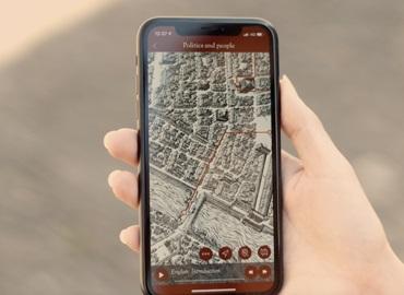 A hand holding a phone with the screen showing a map.