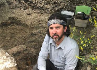 David Evans sitting at the site of the dig