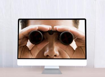 Desktop with screensaver of man using binoculars