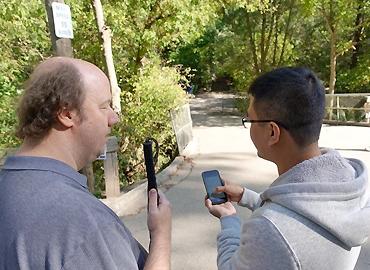 Bin Liu testing MapinHood with a pedestrian in a park on a bright sunny day.