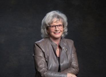 Headshot of Linda Schuyler in front of a grey backdrop