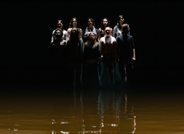 10 youth standing in muddy water in the dark