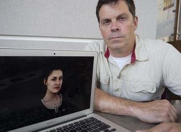 Matt McPherson next to a laptop computer with a woman on the screen