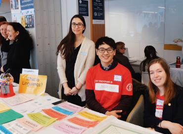 Staff and students at a booth representing the Linguistics program at program exploration fair