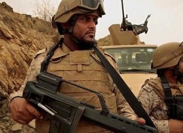 Two Saudi soldiers holding rifles while on patrol.