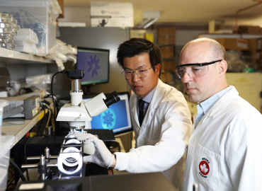 Two scientists adjusting a microrobot in a lab