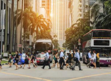 A group of people walk down a busy street.