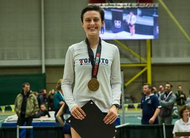 Gabriela DeBues-Stafford, standing proudly with a medal around her neck.