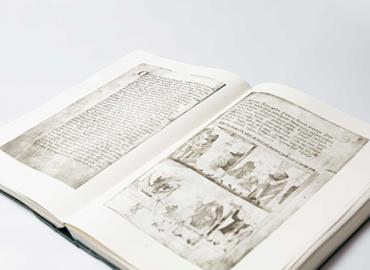 An old english dictionary opened to a page with some small writing and drawings