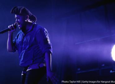 The Weeknd singing, bathed in blue light.