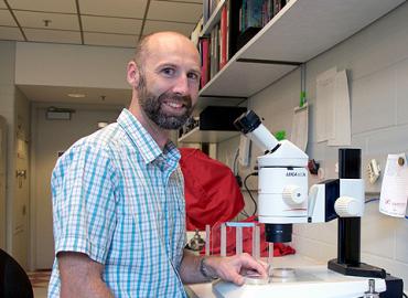Professor Asher Cutter smiling in a lab.