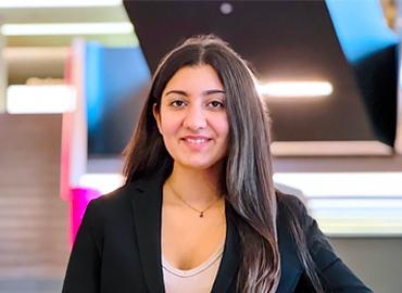 Aamyneh Mecklai standing in front of an indoor concrete staircase