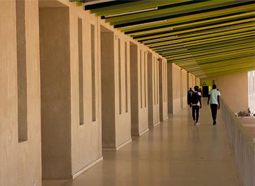 Two people walking down a long hallway.
