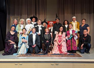 A large group of people in costumes on a stage.