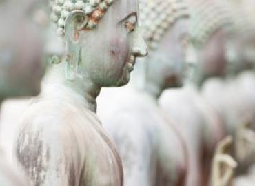 A picture of five white statues, four blurred out and one in focus.