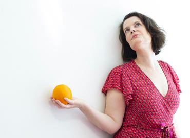 Catia Dignard holding an orange.