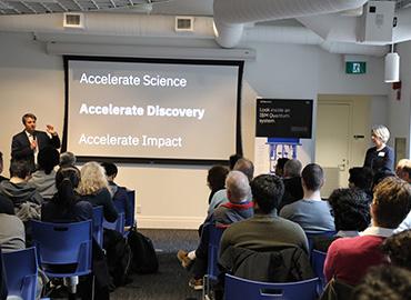 A large group of people watching a conference presentation