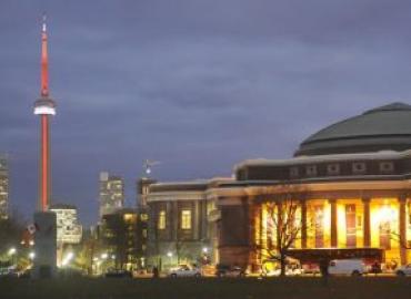 Convocation Hall and the CN Tower lit up at night