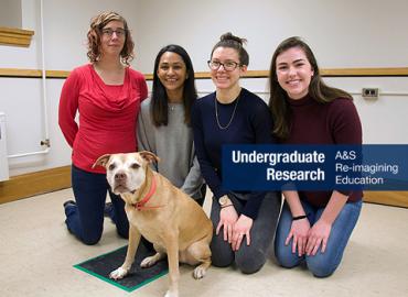 Three students with their professor and Pumpkin the golden retriever