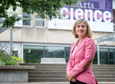 Dean Melanie Woodin stands in front of Sidney Smith Hall.