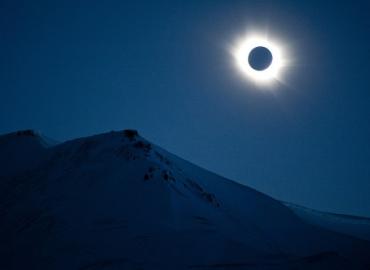 A total solar eclipse above a mountain