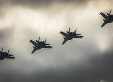 Russian fighter jet formation flying across a grey sky.