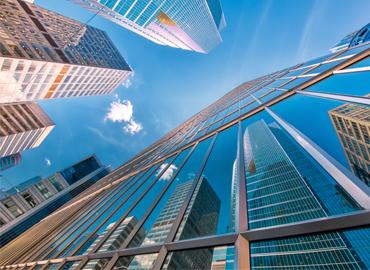 An outside view of skyscrapers under a blue sky.