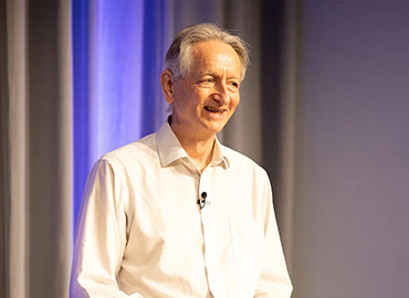 Geoffrey Hinton, a University Professor emeritus of computer science at the University of Toronto stands on a stage