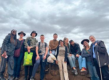 A group of people standing with a bright sky above them in the Altiplano.