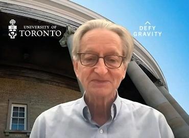 Geoffrey Hinton in front of a Convocation Hall background at a press conference on YouTube