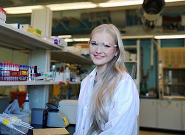 A woman sitting on a chair in a chemistry lab