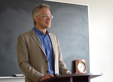 John Zilcosky standing at a podium at the head of a class