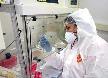 Julia Kreiner in full lab protective gear working on her research