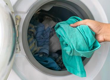 hand taking laundry out of washing machine